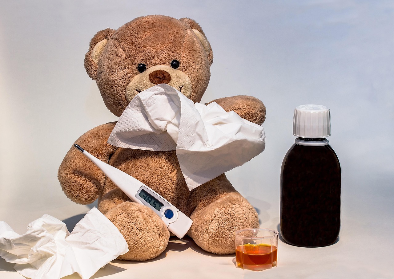 Thermomètre, mouchoirs et tasse de thé chaud sur une table de chevet pendant une grippe